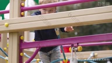小男孩攀登操场设备户外活动儿童